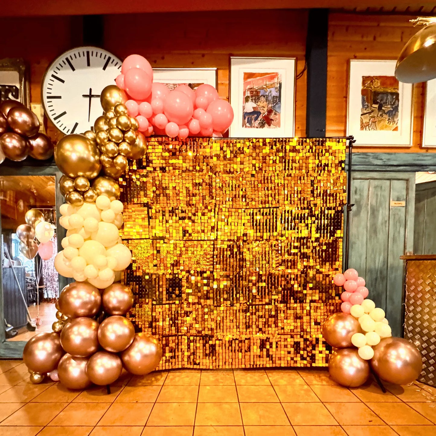 A luxurious gold sequin wall paired with a premium balloon garland featuring gold, blush pink, and white balloons in various sizes. This elegant setup creates a dazzling backdrop ideal for weddings, birthdays, and special events, adding glamour and sophistication to the venue. | The Party Hut Cheltenham